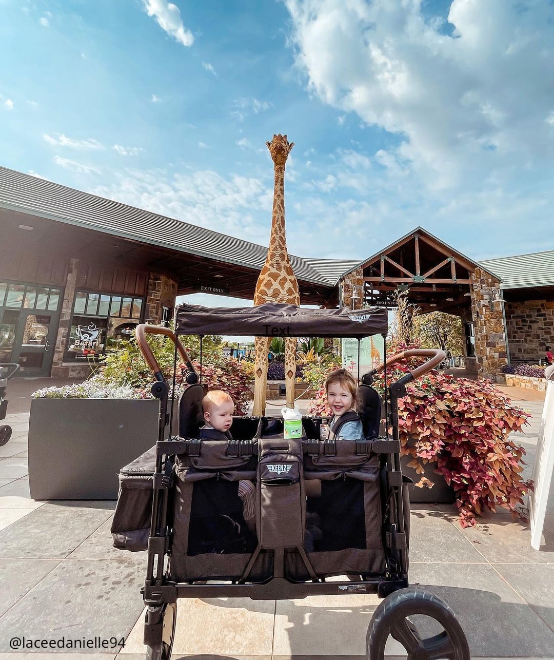 black Keenz stroller wagon carrying two kids at the zoo
