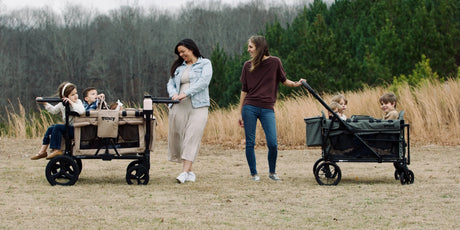 Keenz MOOV and VIVA stroller wagons side by side on a family outing in an open field